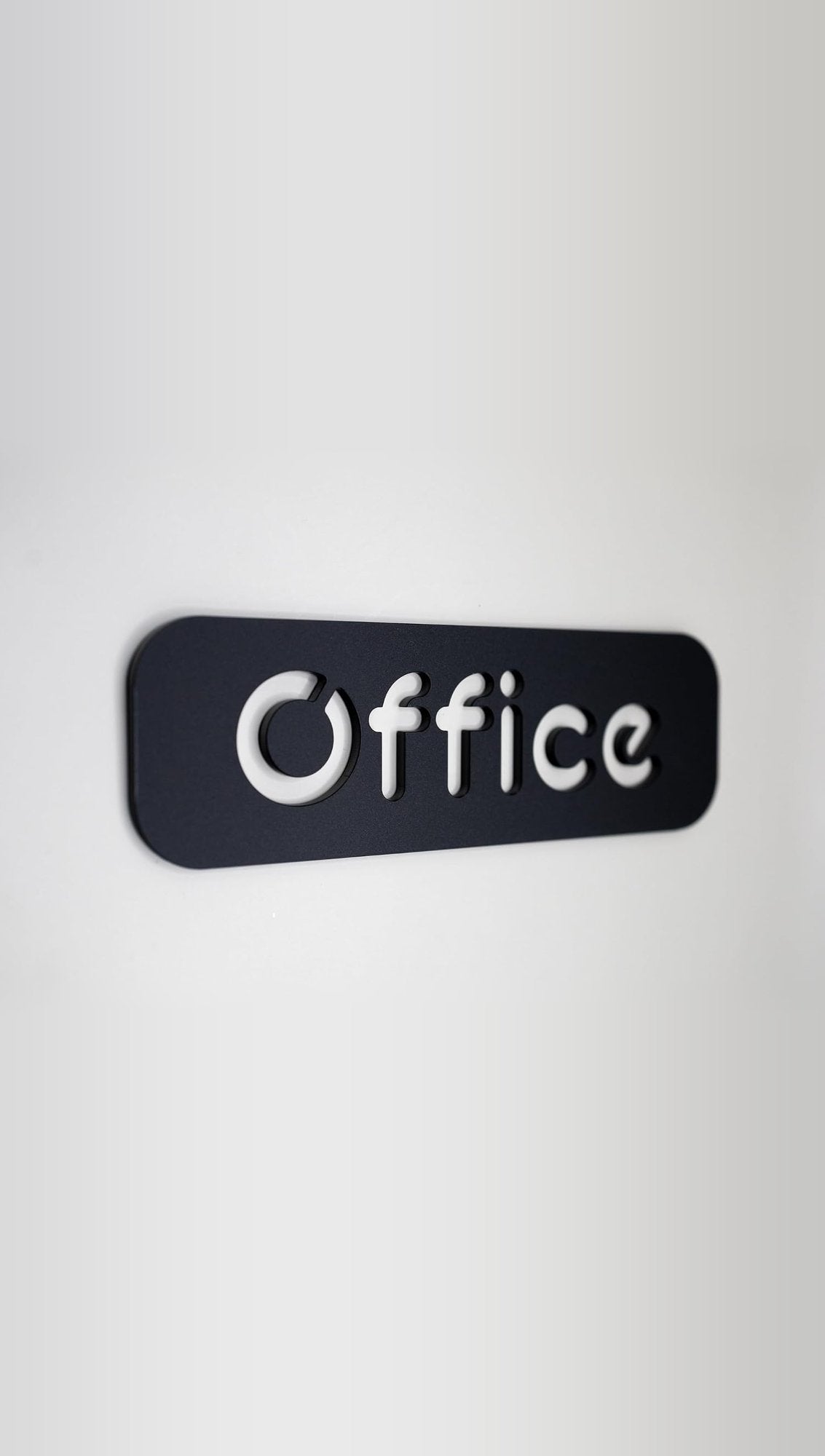 Black door sign with raised white Office lettering mounted on a wall