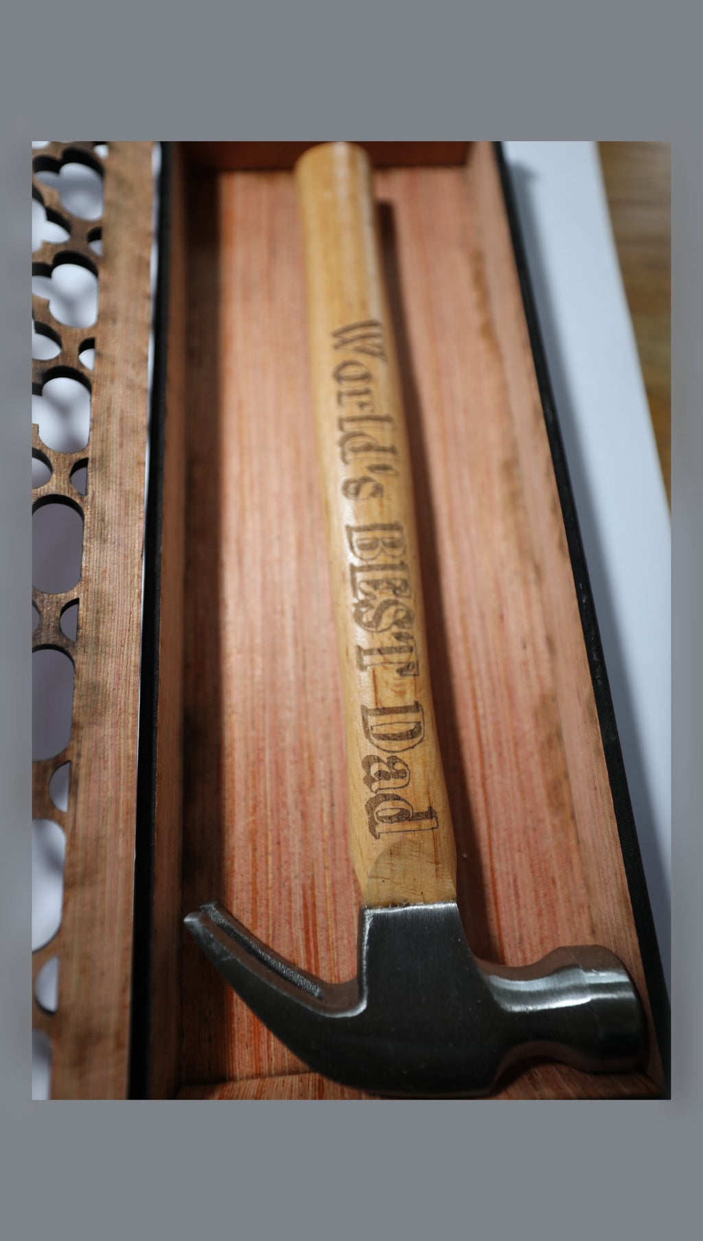 Open wooden gift box showing fretwork lid and engraved hammer handle