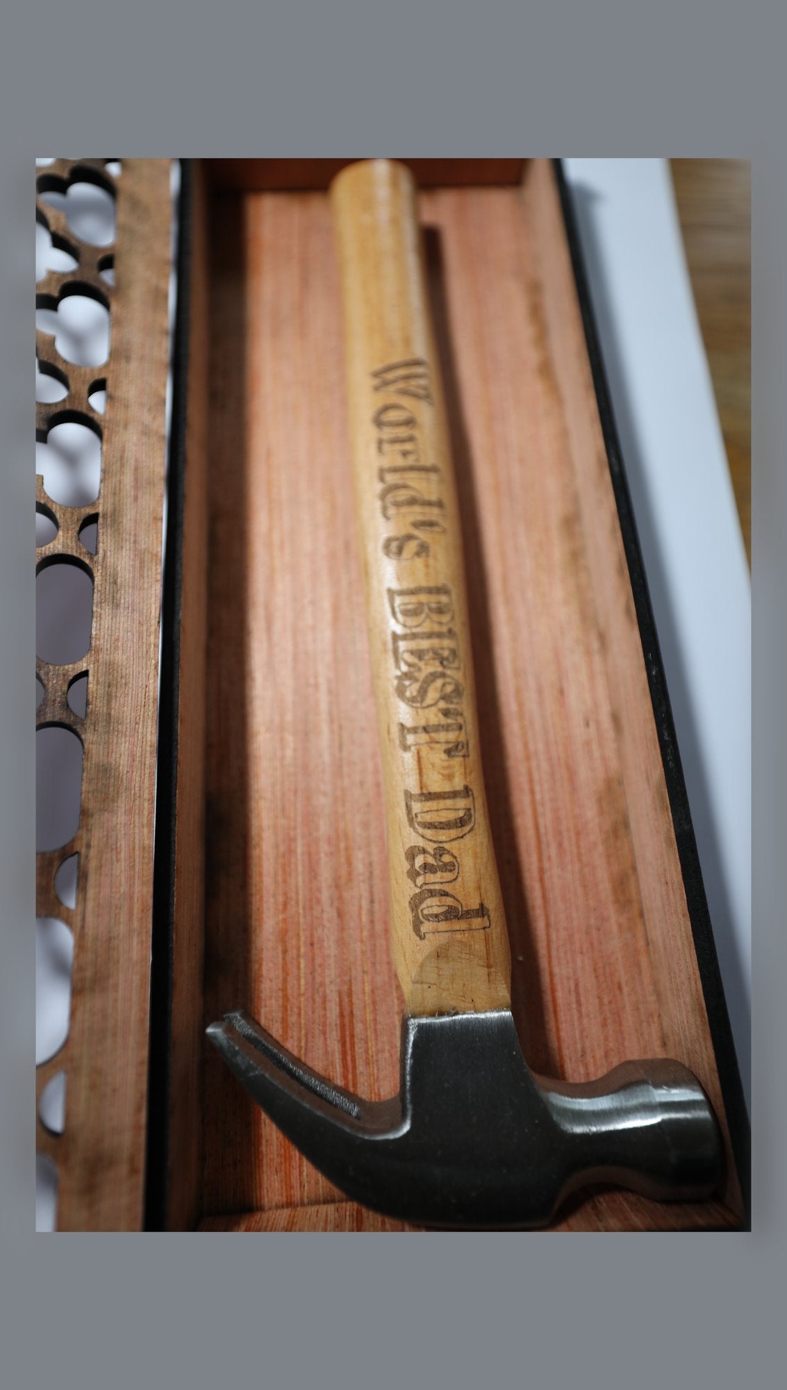Open wooden gift box showing fretwork lid and engraved hammer handle