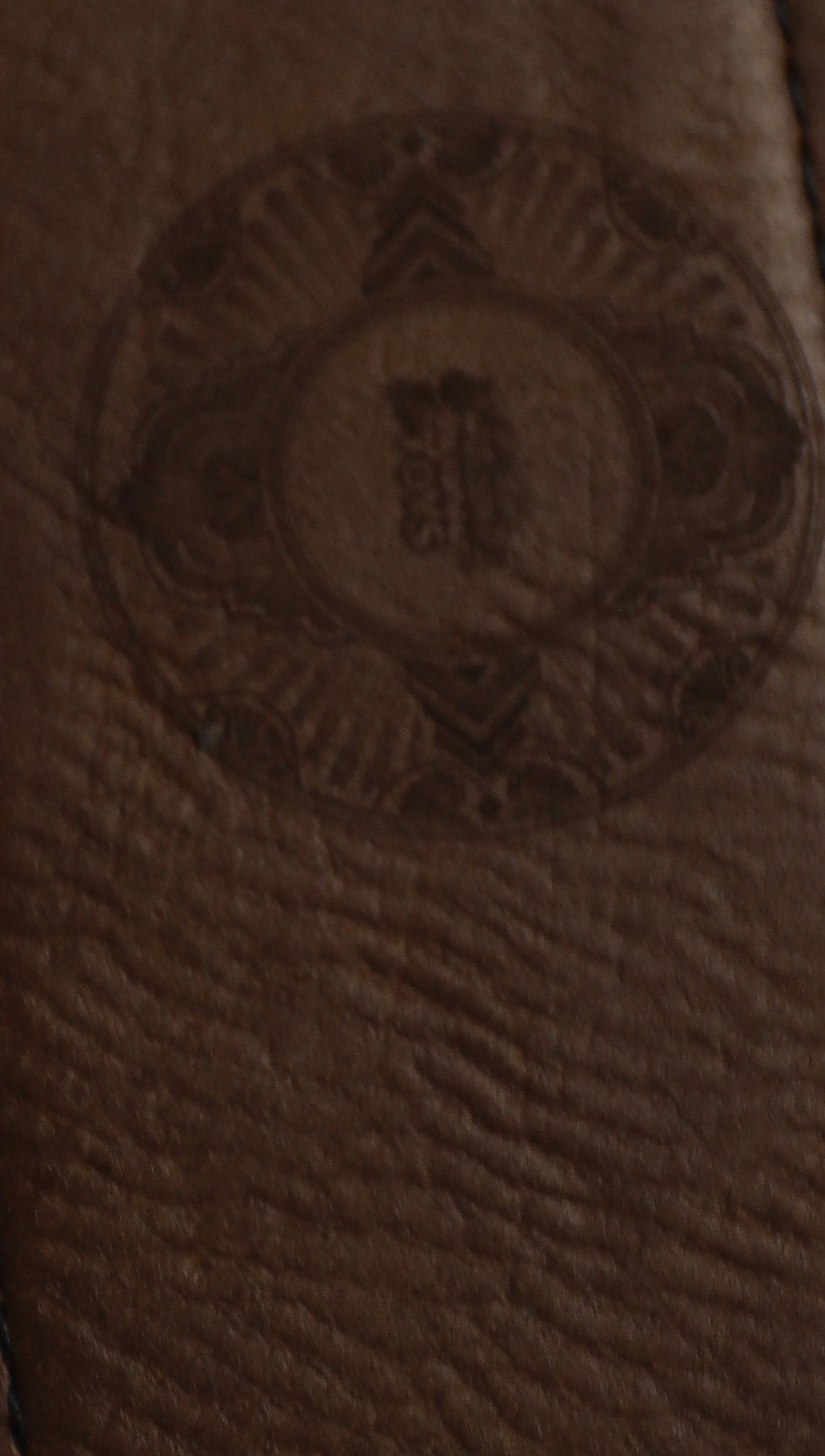 Close-up of laser engraving on leather sleeve of bar blade bottle opener