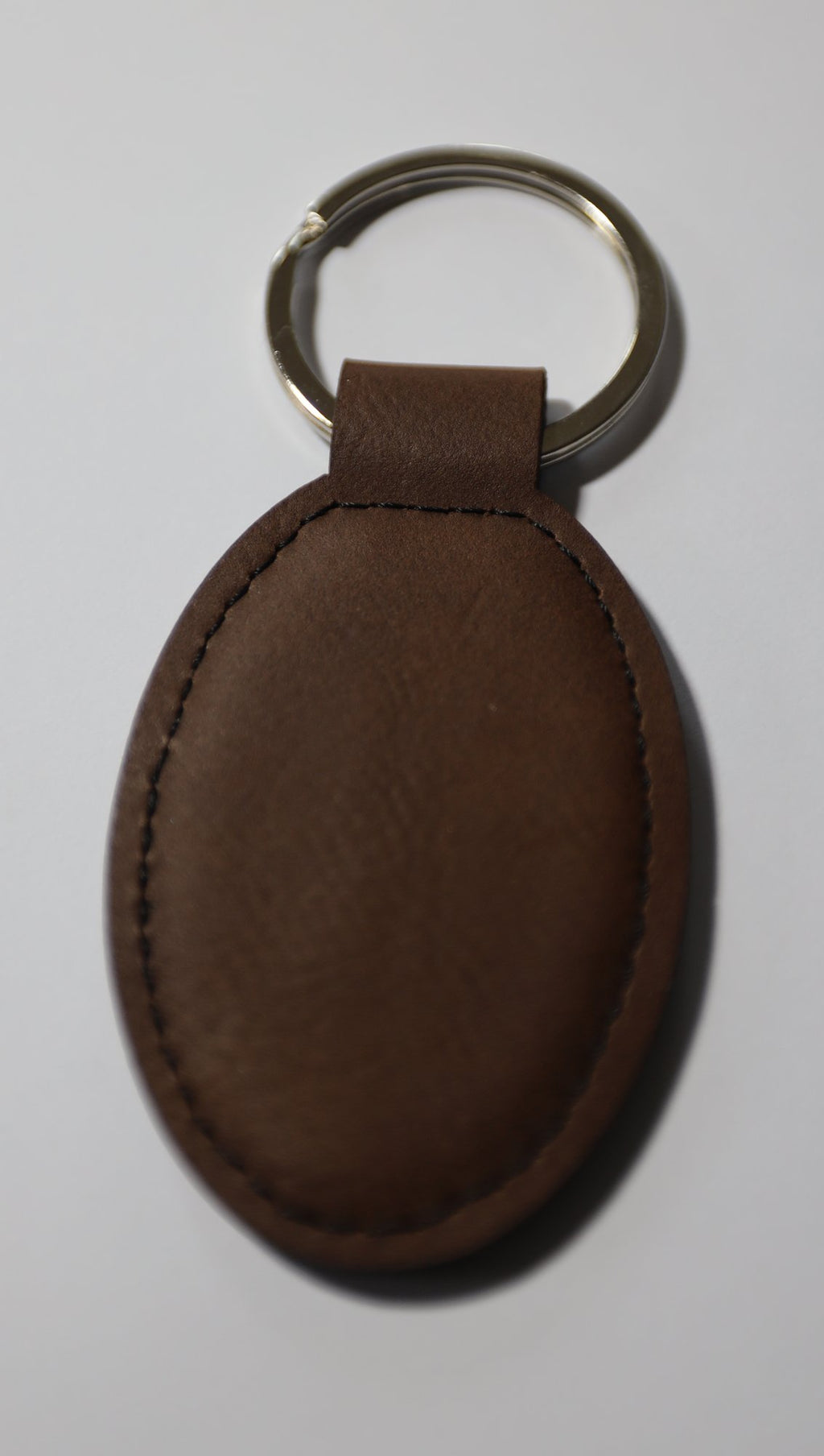 Blank brown oval faux leather keyring before engraving