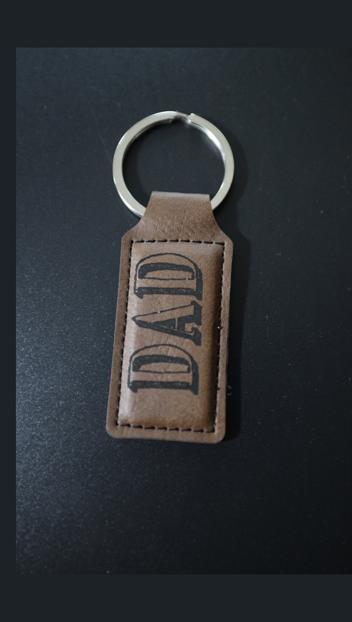 Rectangle faux leather keyring with sample engraving on dark background