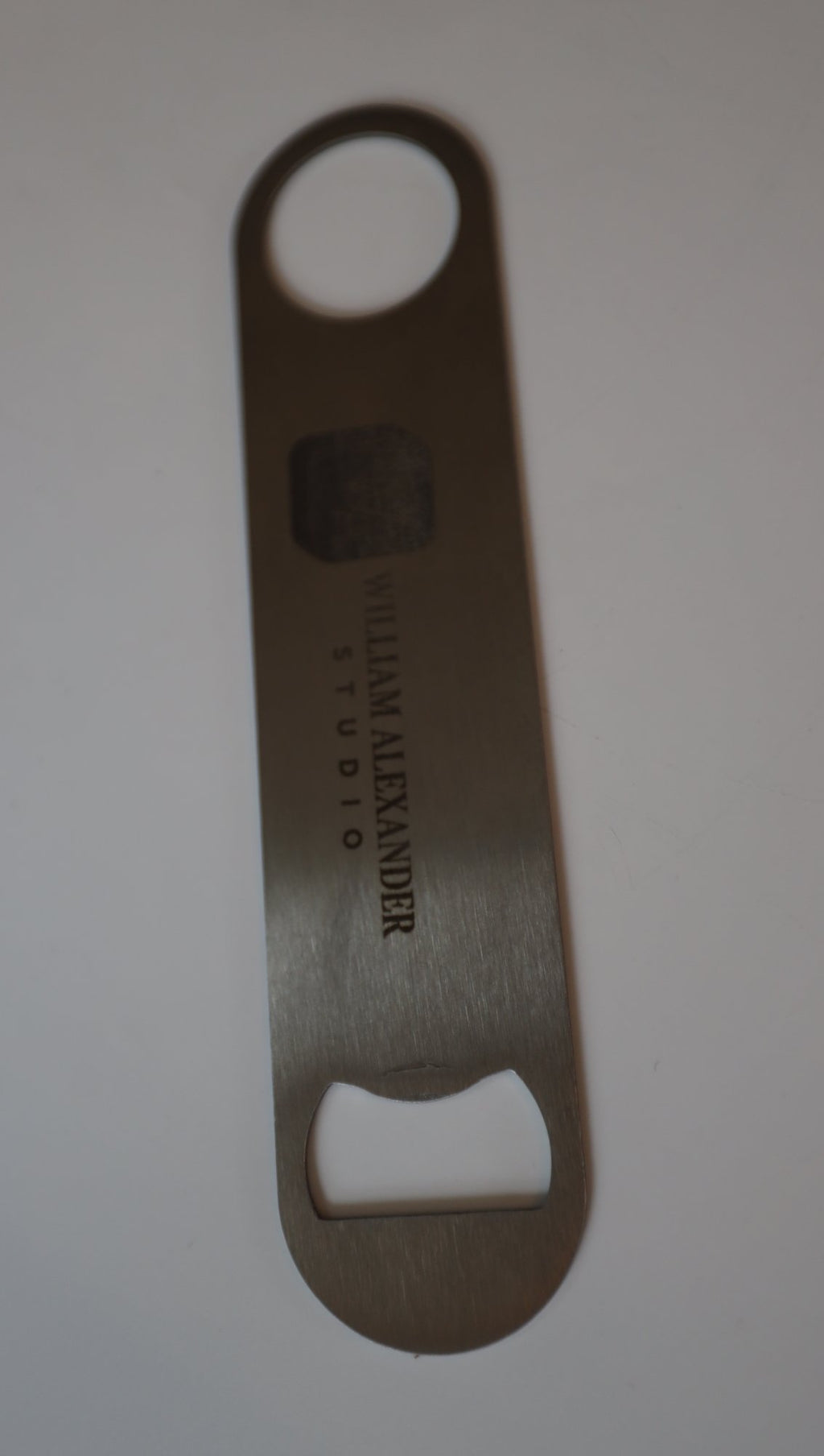 Stainless steel bar blade with sample Studio logo, upright on light background
