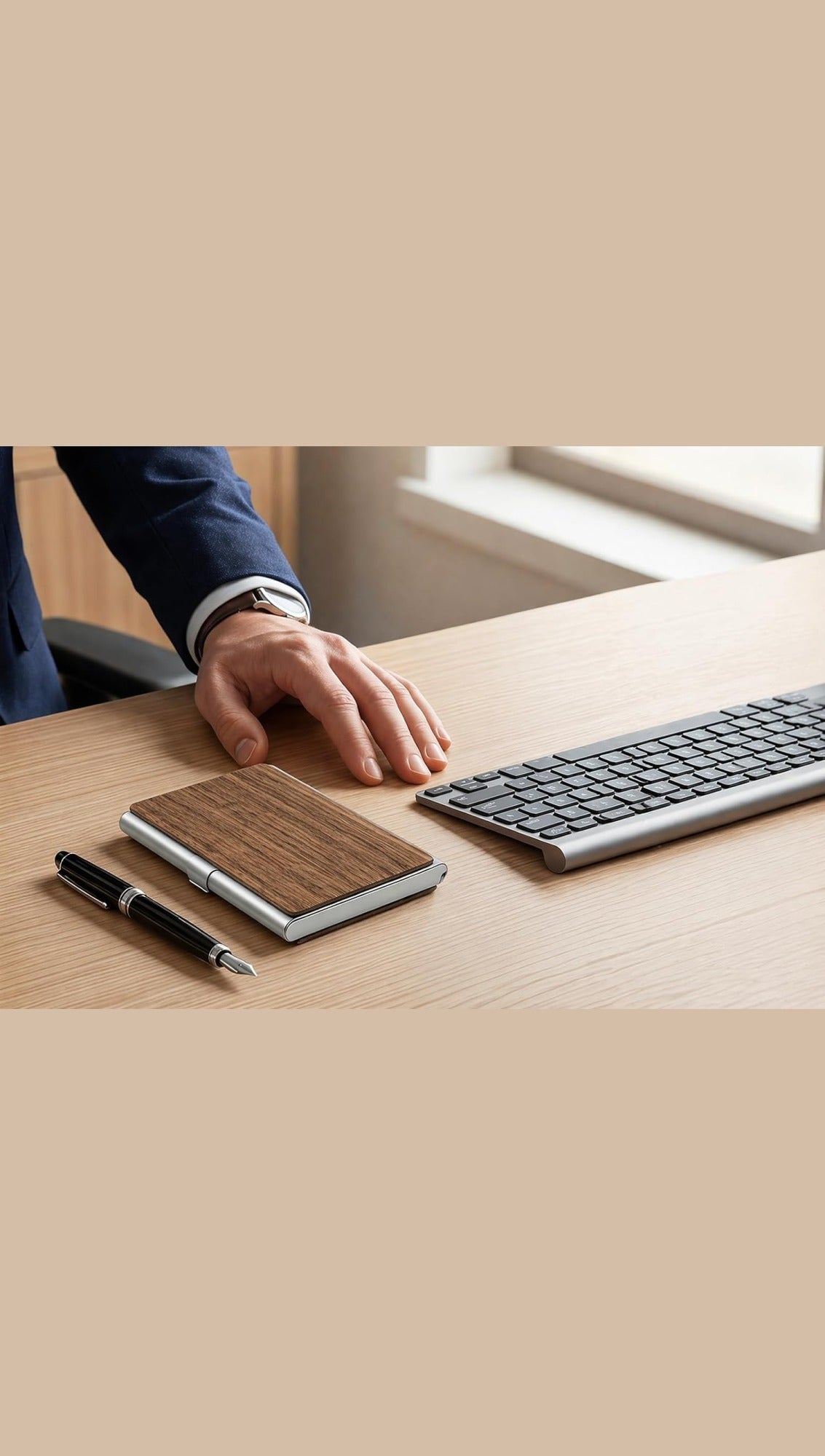 Walnut and aluminium business card holder on an office desk beside a pen and keyboard, blank before engraving