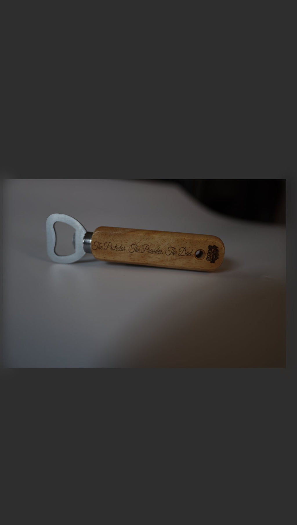 Wooden handle bottle opener with sample engraving, lying flat