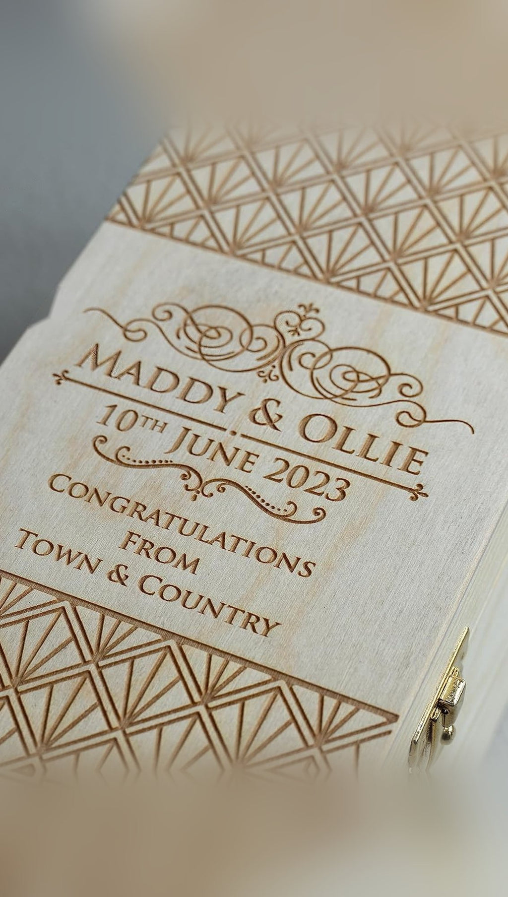Close-up of a laser-engraved pine whisky box lid with sample wedding names, date and Art Deco pattern