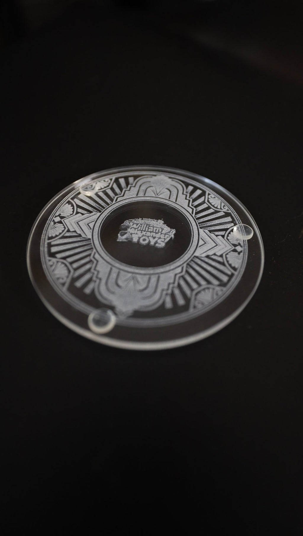 Etched glass coaster, angled view showing clear feet