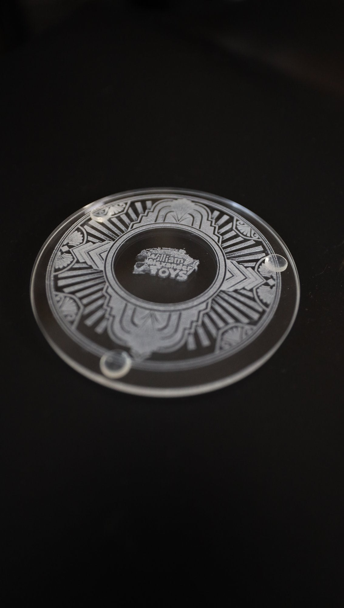 Etched glass coaster, angled view showing clear feet