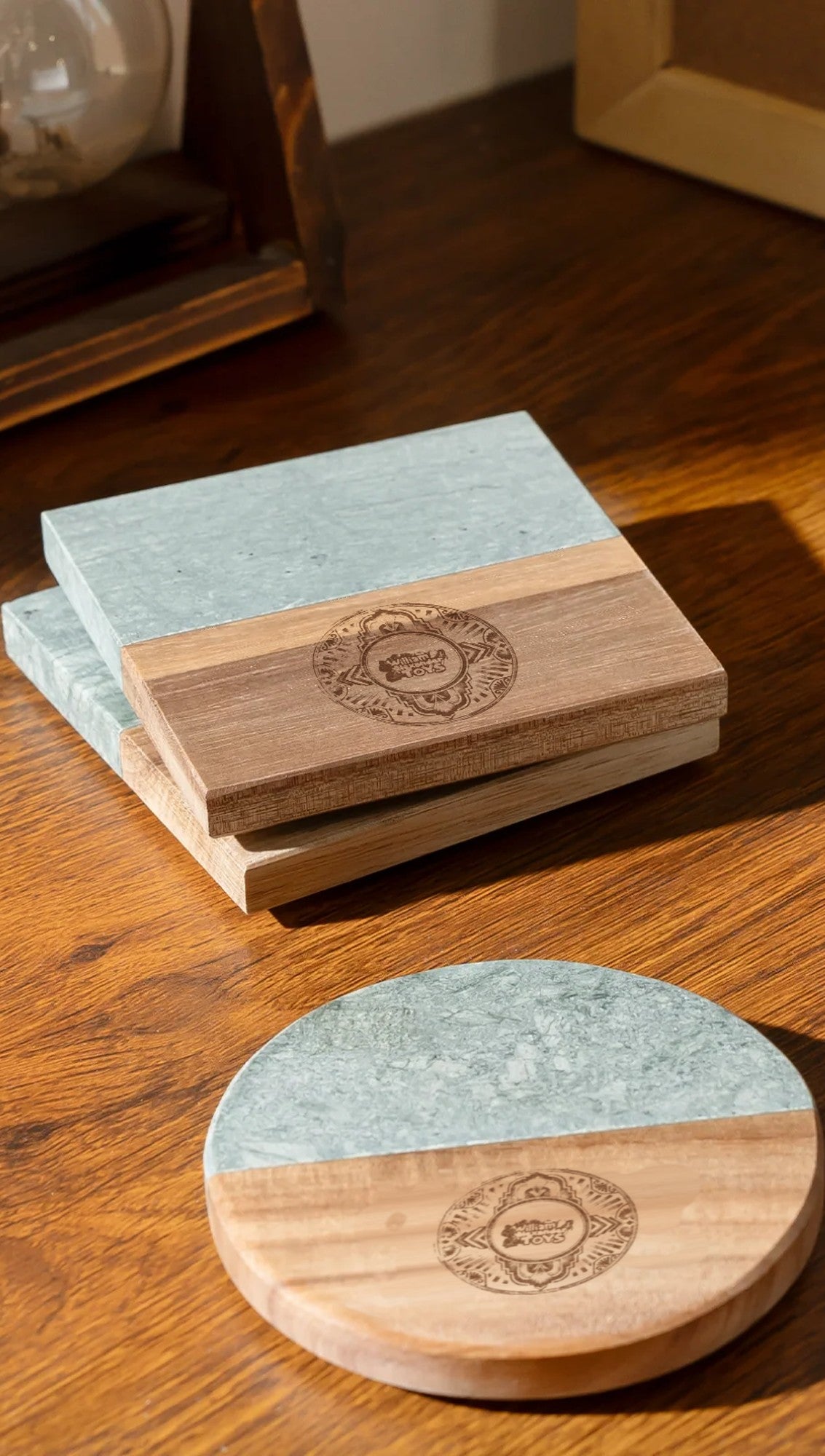 Engraved marble and wood coasters on a wooden table