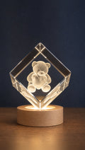 Chamfered crystal diamond with a 3D-engraved design, standing on its LED base